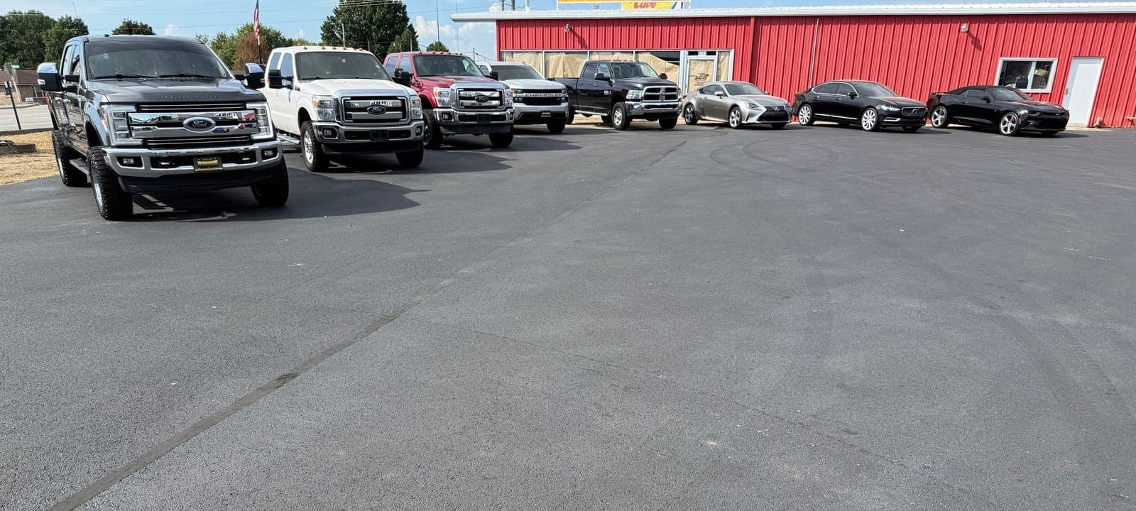 Used trucks and cars parked in a row on the Ironwood Motorsports lot